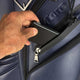 Hand placing a phone into a compartment of a blue suitcase.