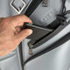 Hand opening a compartment in a suitcase with 'Llote' branding.