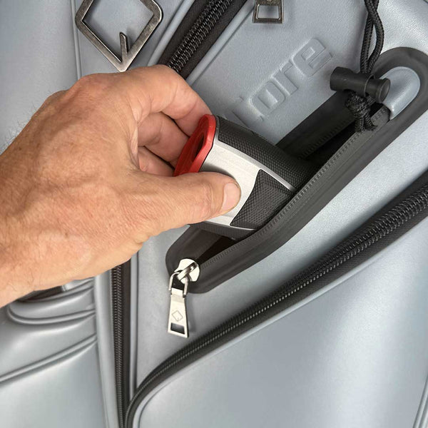 Hand using a red suitcase lock on a gray suitcase