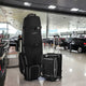 Black travel bags on display in a car showroom.